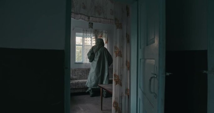 Consequences of the Chernobyl catastrophe in the USSR on April 26, 1986. Soldier dosimetry measures the level of radiation pollution in the room of a rural home.
