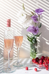 bottle and glasses of rose wine flowers and fruit