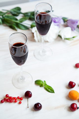 glasses of red wine flowers and fruit