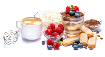 Classic tiramisu dessert with blueberries and raspberries in a glass, savoiardi and mascarpone cheese isolated on a white with clipping path