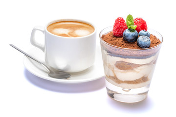 Cup of cofee and Classic tiramisu dessert with blueberries and raspberries in a glass isolated on a white background with clipping path
