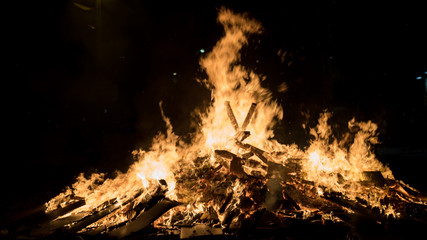 Fire in the night. Big fire during the celebration of Saint Joan holiday in Barcelona. Big flames in the evening. Yellow fire details.