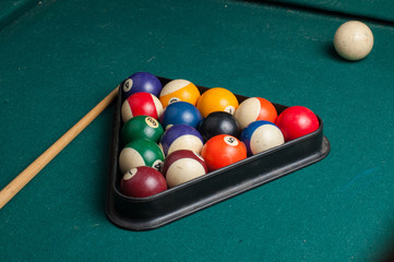 Old billiard balls and stick on a green table. billiard balls isolated on a green background.