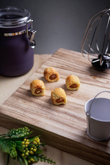 Pineapple tarts or nanas tart on wooden plate it is small bite size pastries filled with pineapple jam