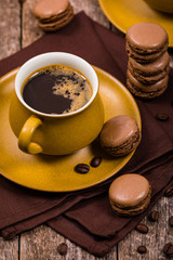 French Chocolate Macarons with Coffee Beans on Wooden Table. Selective focus.