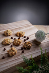 A chocolate chips cookies with jar, flower and retro clock as background