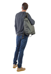 Fototapeta premium Back view of a man with a green bag.