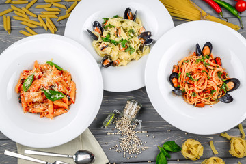 Mediterranean style lunch. Spaghetti with canned mussels and tomato sauce. On a wooden table, top view.
