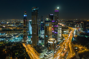 Fototapeta premium Night aerial cityscape with the view on skyscrapers and full moon