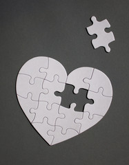 White heart shaped puzzle with missing part. - obrazy, fototapety, plakaty