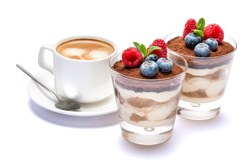 Cup of cofee and Classic tiramisu dessert with blueberries and raspberries in a glass isolated on a white background with clipping path