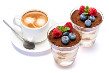 Cup of cofee and Classic tiramisu dessert with blueberries and raspberries in a glass isolated on a white background with clipping path