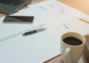 Business Document Report, Laptop, Pen , Smartphone And white Coffee Cup on desk.