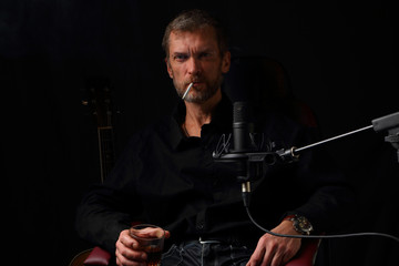 Brutal man with a glass of whiskey and a cigarette