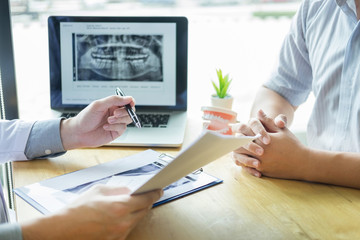 Dental hygienist demonstrating and showing a dummy jaw to chack-up or healing teeth  patient.