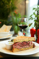 Pastrami sandwich with mustard and red wine