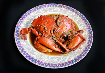Crab in Padang sauce or Padang crab (Indonesian: Kepiting saus Padang) on black background.