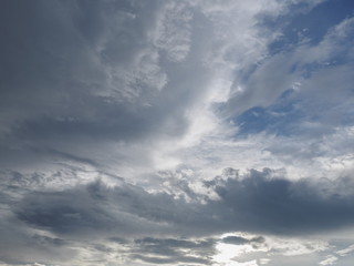 Cloudy sky background, view of fat dark clouds moving in soft rain with blue sky background.