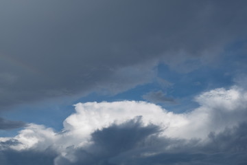 Fototapeta na wymiar Cloudy sky background, view of fat dark clouds moving in soft rain with blue sky background.