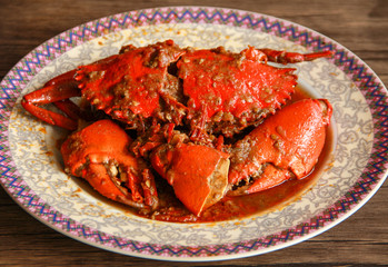 Crab in Padang sauce or Padang crab (Indonesian: Kepiting saus Padang) on wood background.