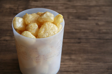 Cattle skin crackers on wood background.