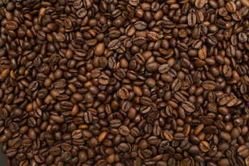 Fototapeta premium Roasted coffee beans brown seeds texture background wallpaper. Top view.