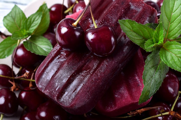Cherry popsicle on berries topped with mint