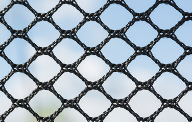 Macro photograph of a black nylon mesh fabric. Details, textures and backgrounds