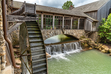 Wooden walkway over a water spill with water wheel
