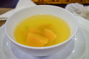 Pumpkin soup in a plate with a spoon in a restaurant