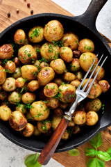 Fried, young potatoes with spices in a pan. View from above.