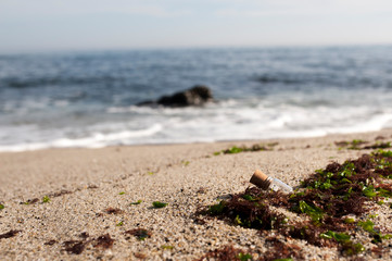 Digital message in a bottle in sand on the beach