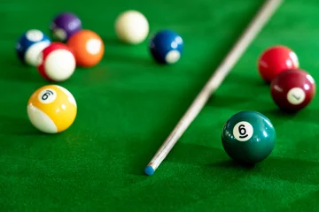 Foto op Plexiglas Man's hand and Cue arm playing snooker game or preparing aiming to shoot pool balls on a green billiard table. © Pichsakul