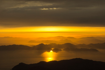 Mountains and the sea, sunset, sky in pastel colors, light haze, blur.