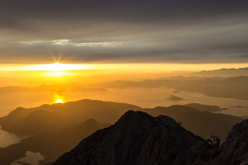 Mountains and the sea, sunset, sky in pastel colors, light haze, blur.