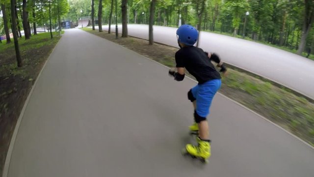 Kids fun cardio training. Fast inline skating. Boy speeding through the park.