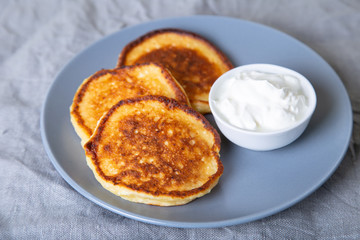 Cottage cheese pancakes (syrniki). Homemade cheesecakes from cottage cheese with sour cream. Traditional Russian dish. Close-up.