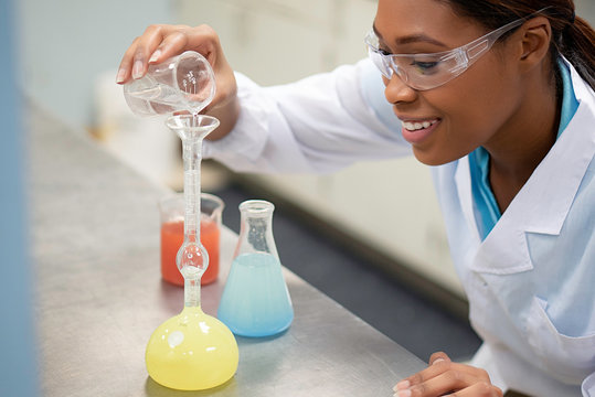 Close up of scientist pouring solution into flask