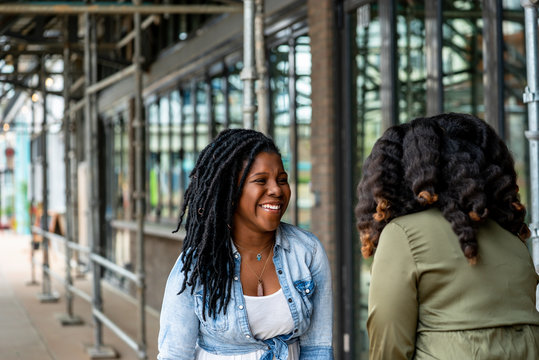 Woman with dreadlocks smiling at friend