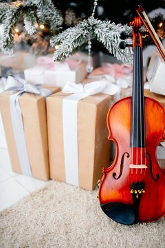 Violin, christmas decorations on the wooden background.