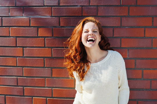 lachende Frau mit langen roten Haaren