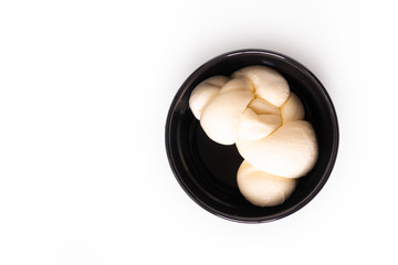 Food ingredient concept organic mozzarella cheese in black ceramic cup with copy space