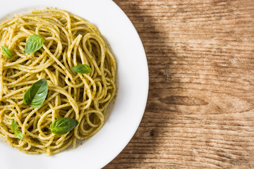 Spaghetti pasta with pesto sauce on wooden table
