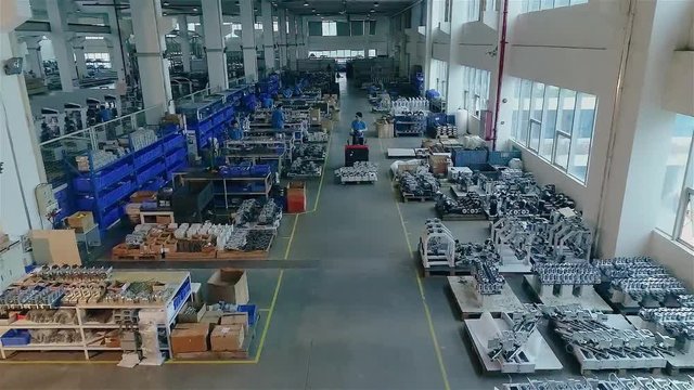 People work in a large modern factory, the interior is a large modern factory. The man on the loader carries the item