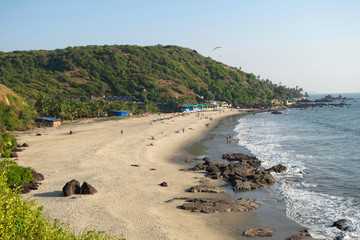 Beautiful Goa beach, sandy coast, rocky stones and sea high view and people at holiday in India, arambol, sweet lake