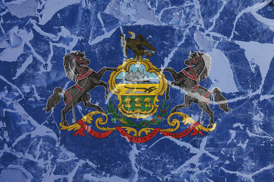 The national flag of the US state Pennsylvania in against a gray wall with cracks and faults on the day of independence in  blue and yellow. Political and religious disputes, customs and delivery.