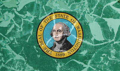 The national flag of the US state Washington in against a gray wall with cracks and faults on the day of independence in green and yellow. Political and religious disputes, customs and delivery.