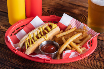 hot dog in basket with draft beer
