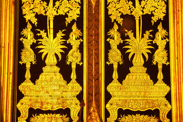 Elegant of traditional Thai style art golden painting on ancient door.
