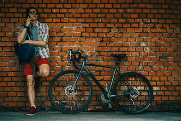 Fototapeta na wymiar A young stylish man posing next to his bicycle.